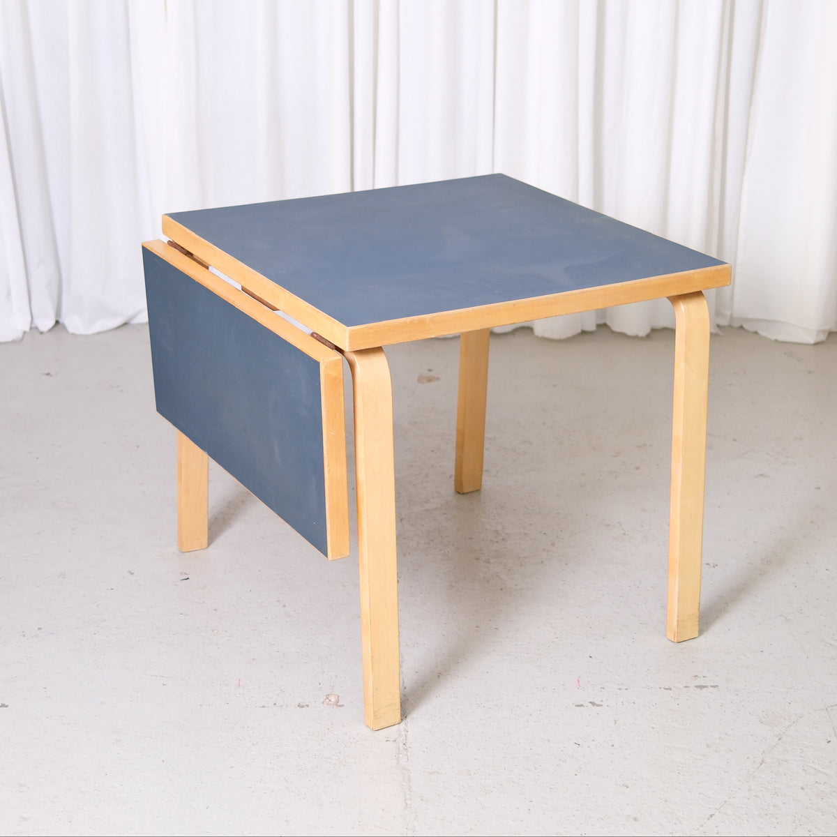 Artek Aalto DL81C drop-leaf table with dark blue linoleum top and birch frame
