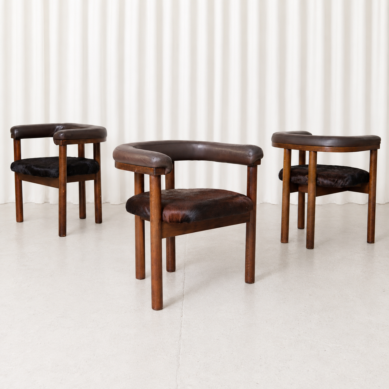 Rare set of three dining chairs by Esko Pajamies for Lepo Finn, featuring wooden frames, curved upholstered backrests and individual cowhide seats.
