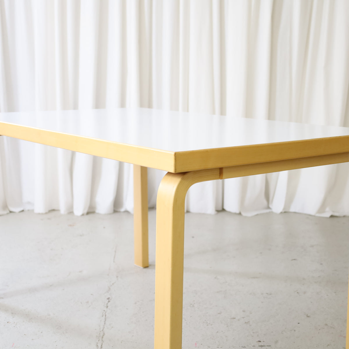 Detail of white laminate top and birch frame on Artek table