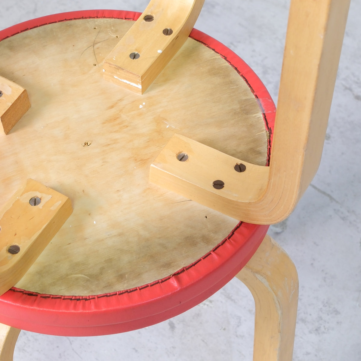 Alvar Aalto E60 -jakkara, valmistaja Artek, punainen verhoilu
