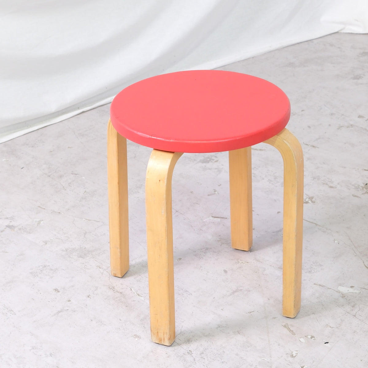 Alvar Aalto E60 -jakkara, valmistaja Artek, punainen verhoilu