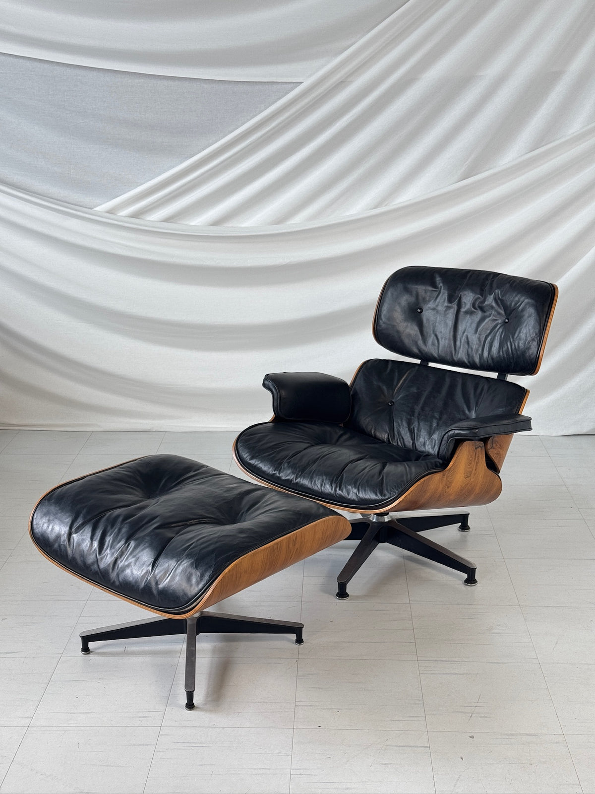 Herman Miller Eames Lounge Chair -lepotuoli ja rahi, ruusupuu ja musta nahka, Yhdysvallat, 1960-luku