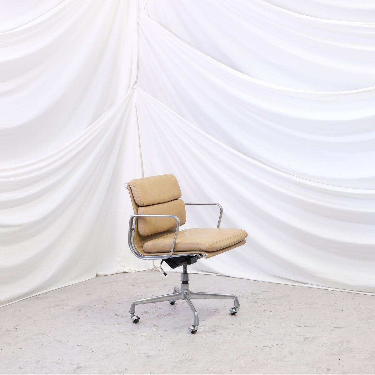 Vintage Charles & Ray Eames Soft Pad chair in beige leather with aluminum frame, castors, and tilt mechanism. Timeless office design. Worldwide shipping available.