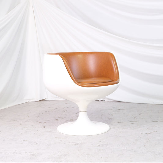 Vintage Eero Aarnio Cognac chair for Asko with white fiberglass shell, cognac faux leather upholstery, and swivel base. Finnish design classic.
