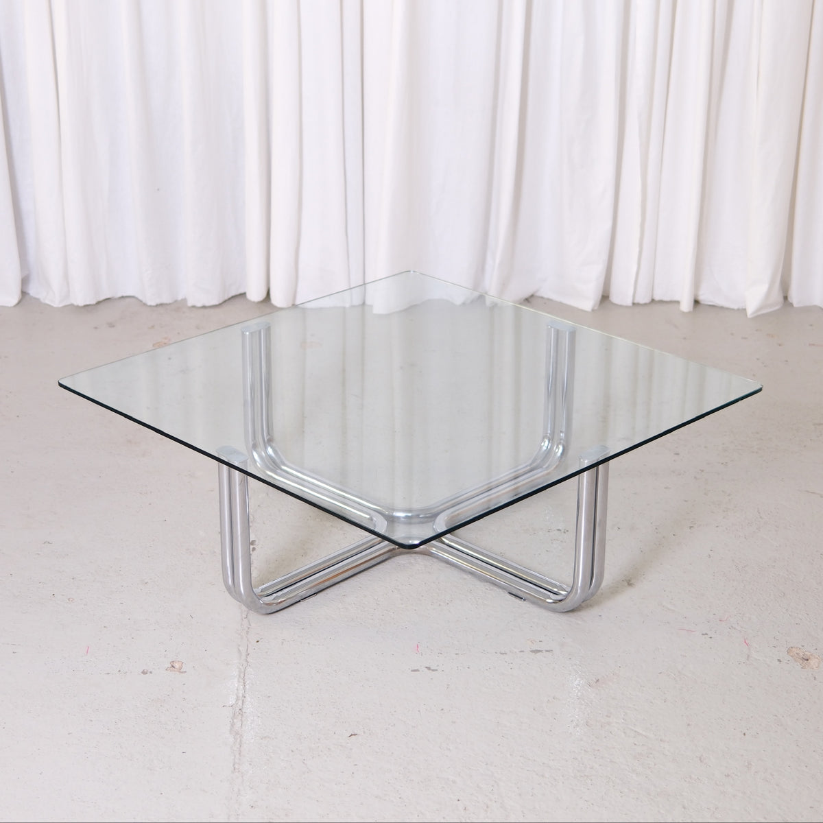 Vintage Italian glass coffee table with square 110 x 110 cm top and chrome tubular steel base. Good vintage condition with minor glass wear.