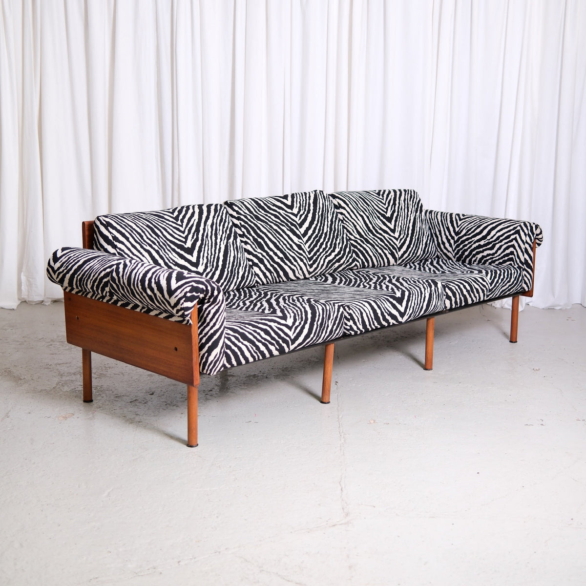 Vintage Yrjö Kukkapuro Ateljee sofa with teak frame, wooden side panels and black and white zebra upholstery.