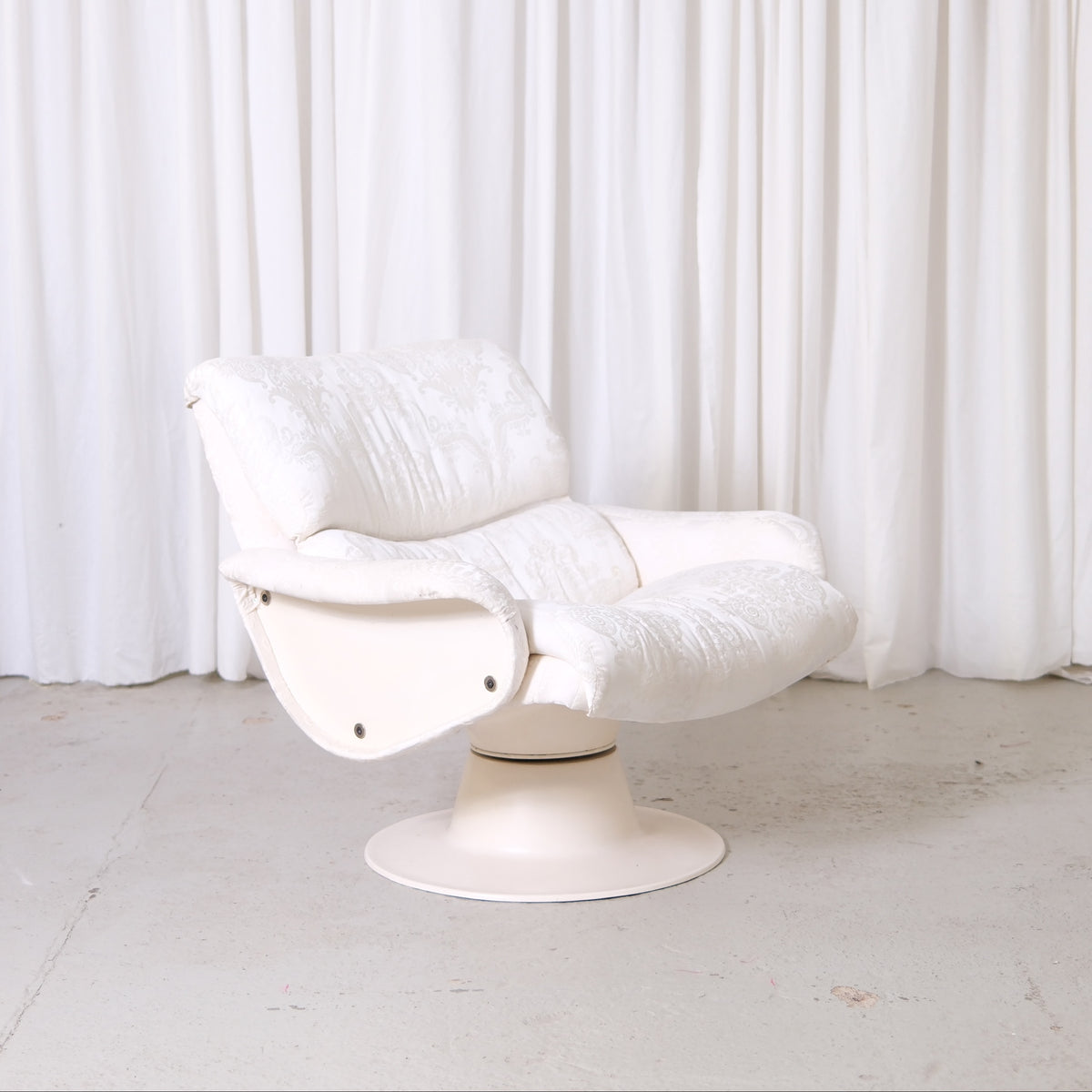 Vintage Yrjö Kukkapuro Saturnus lounge chair with white patterned upholstery and swivel base. Finnish postmodern design classic available from Helsinki.
