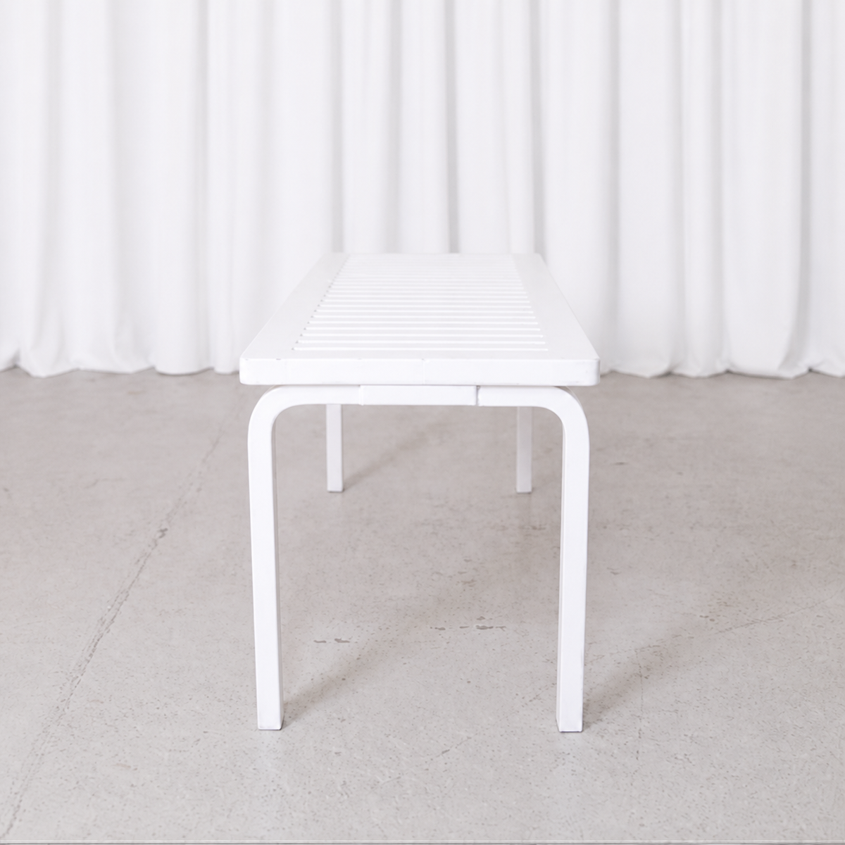 White Artek 153A slatted bench by Alvar Aalto, end view