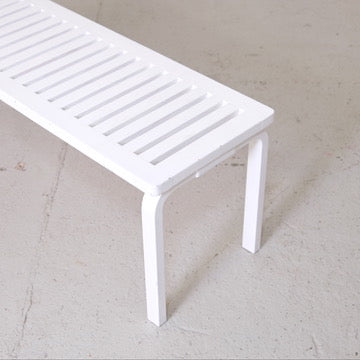Detail of the white-painted slatted top and L-leg on the Artek 153A bench