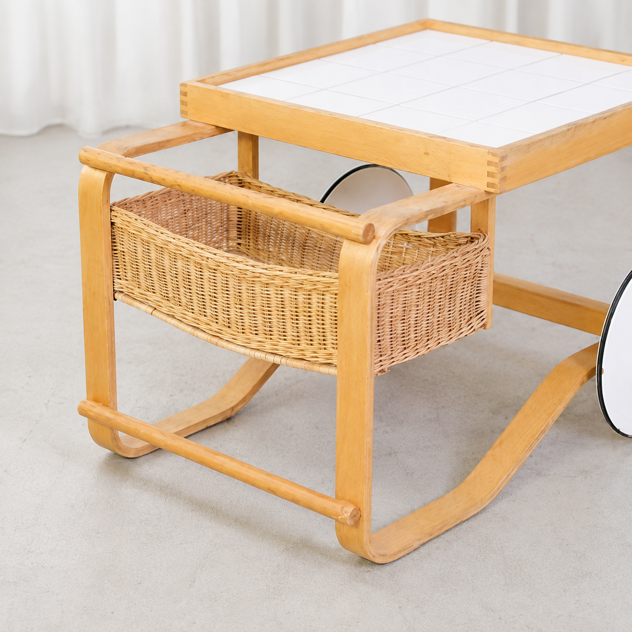 Rattan basket and white tiled top of Artek Tea Trolley 900