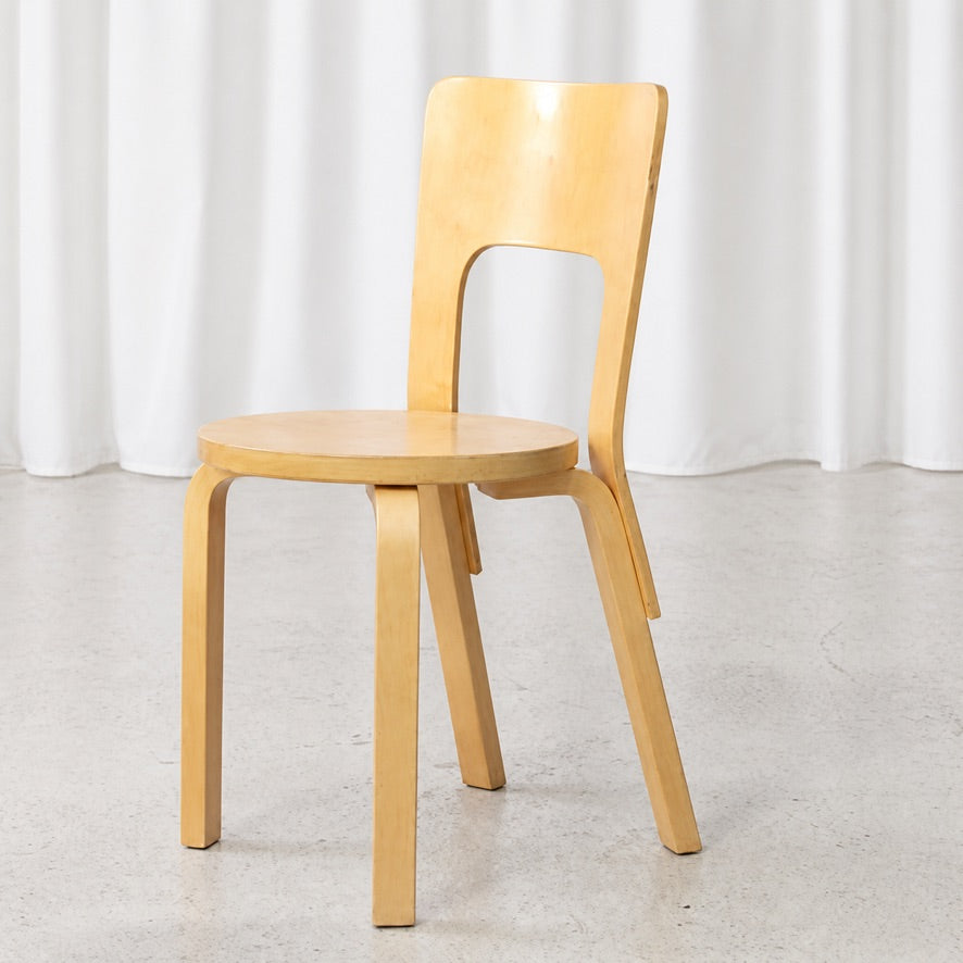 Angled view of an Artek Chair 66 showing the curved birch legs and tall backrest