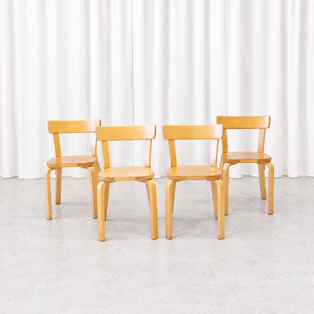 Four vintage Artek Chair 69 chairs in natural birch shown from the front