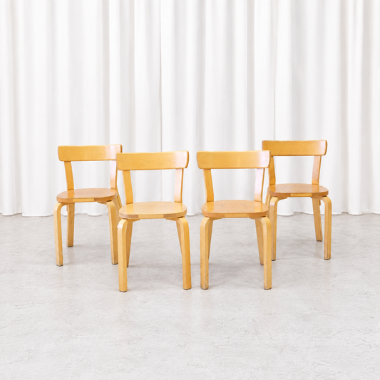 Four vintage Artek Chair 69 chairs in natural birch shown from the front