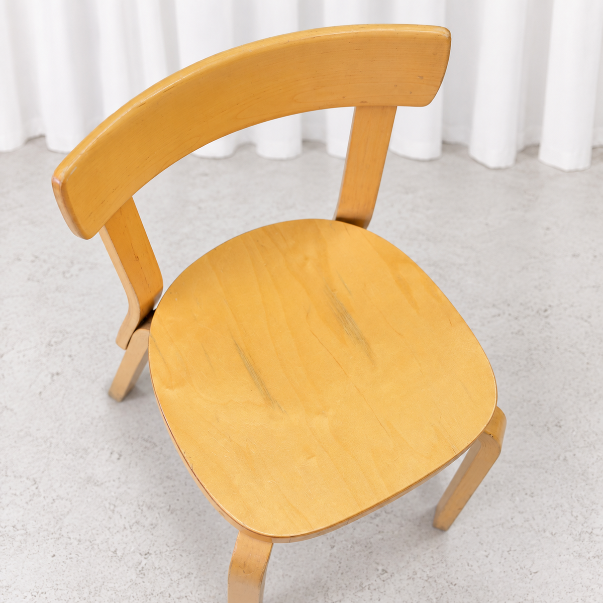 Vintage Artek Chair 69 in birch showing wear and patina on the seat