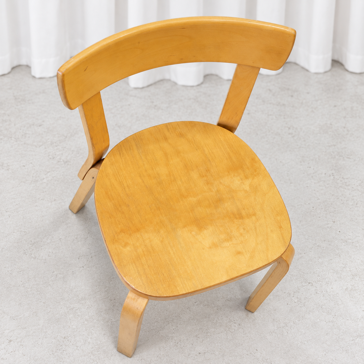 Vintage Artek Chair 69 in birch showing an uneven patina on the seat