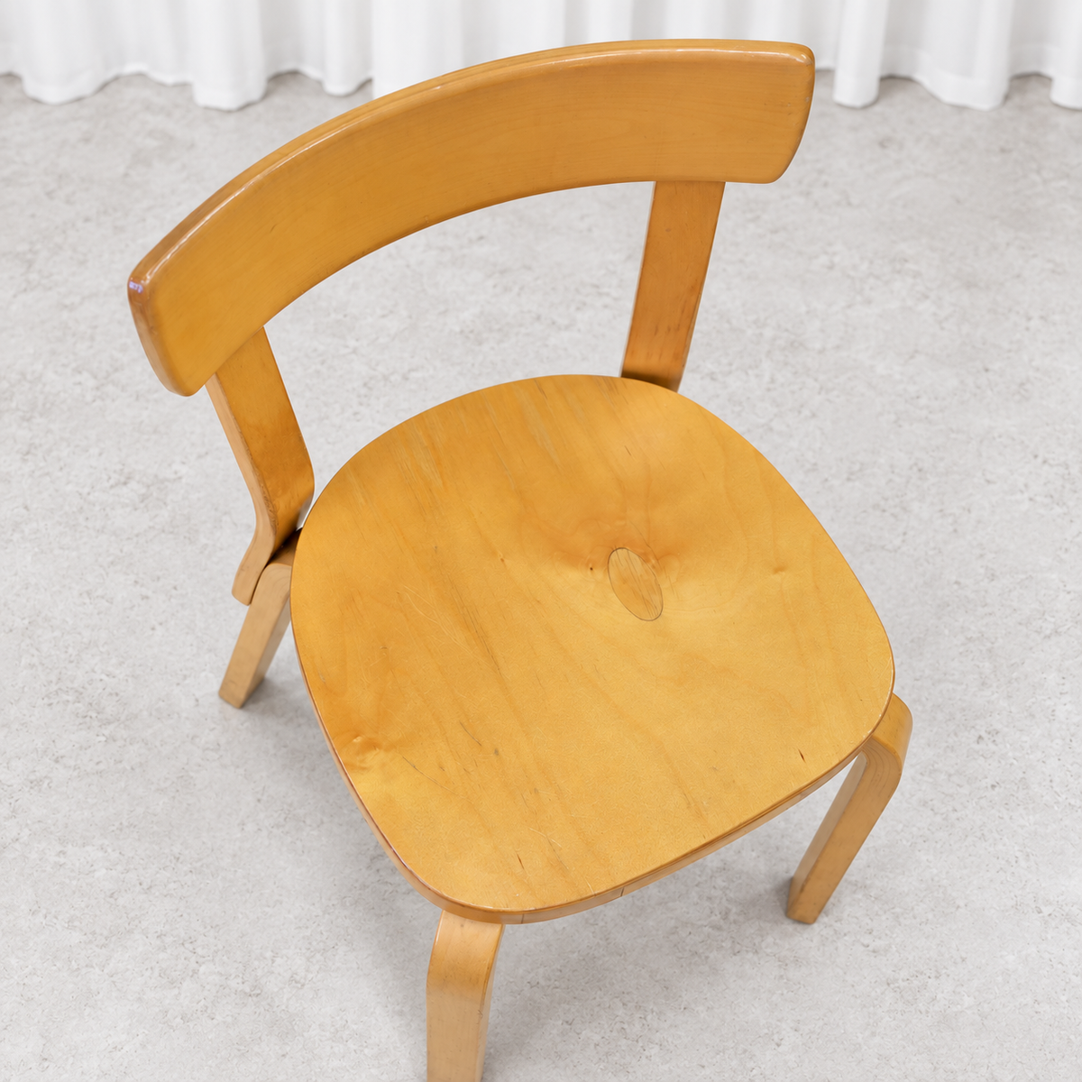 Vintage Artek Chair 69 in birch showing scratches and a visible knot on the seat
