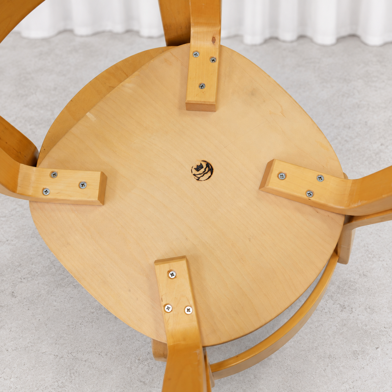 Underside of a vintage Artek Chair 69 showing the birch construction and maker mark