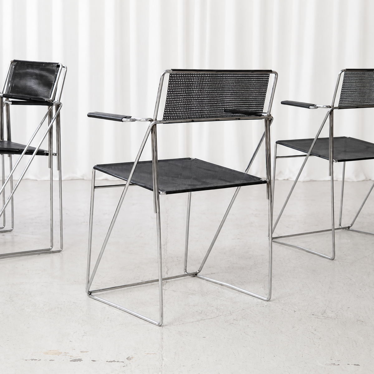 Black and chrome Hybodan X-Line armchair with perforated steel seat and back