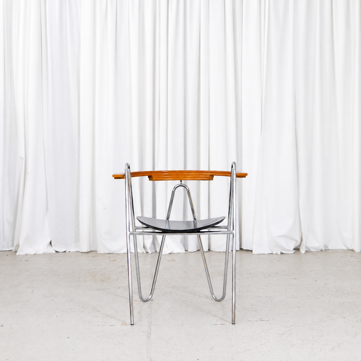 Front view of Pentti Hakala W chair in chrome, black and wood