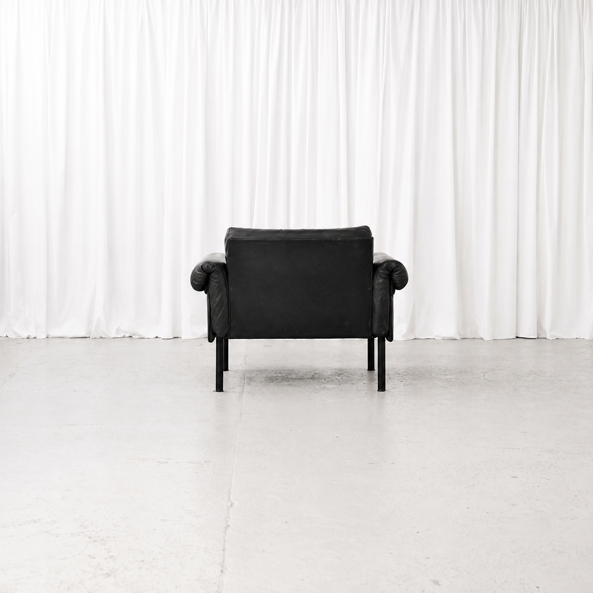 Rear view of a Yrjö Kukkapuro Ateljee armchair in black leather