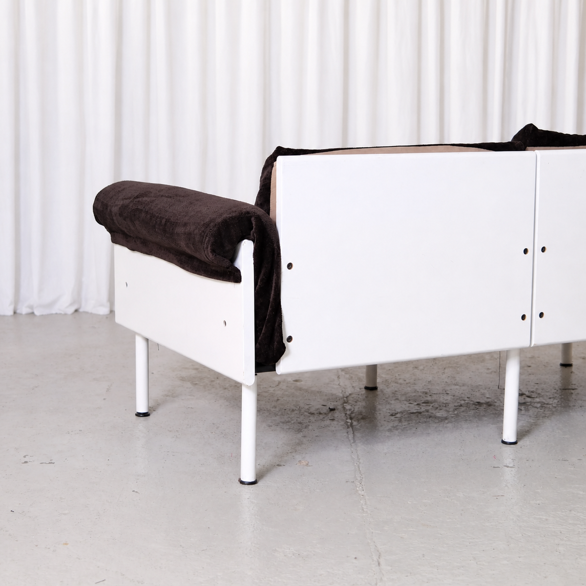 White rear frame and brown velvet arm of Ateljee sofa