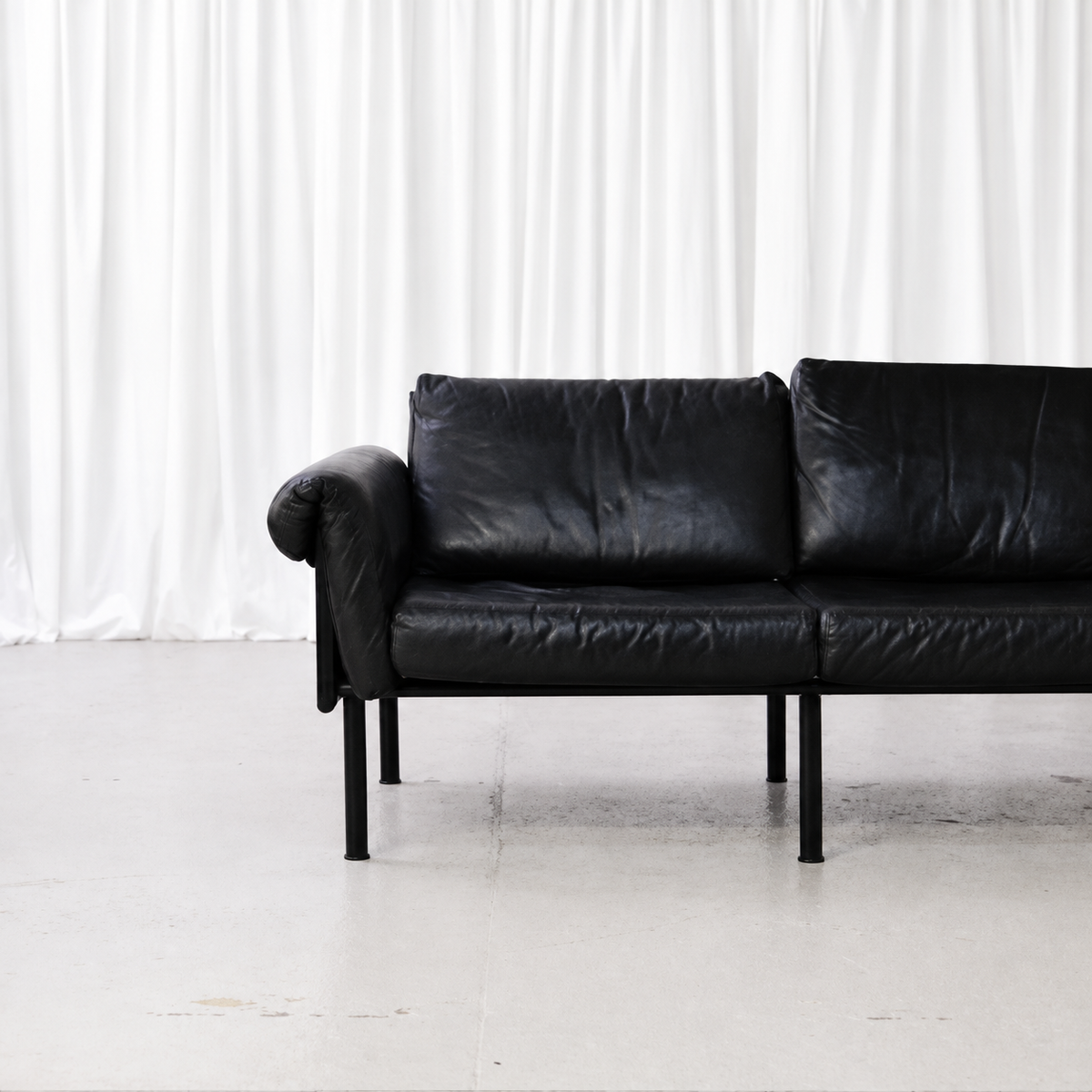 Black leather cushions and arm of Yrjö Kukkapuro Ateljee sofa