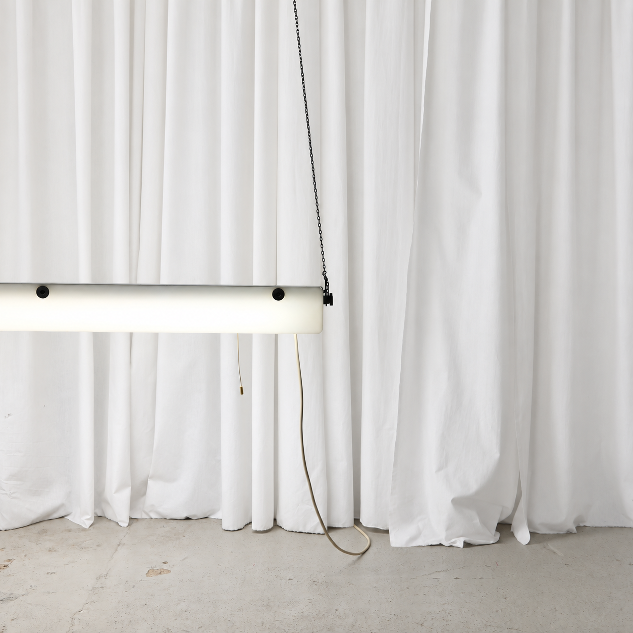Illuminated end view of the white acrylic pendant light with power cable